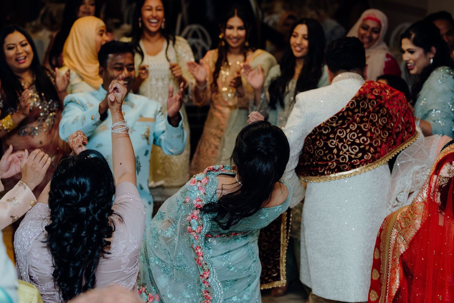 Wedding guests enjoying themselves on the dance floor in traditional formal wear.