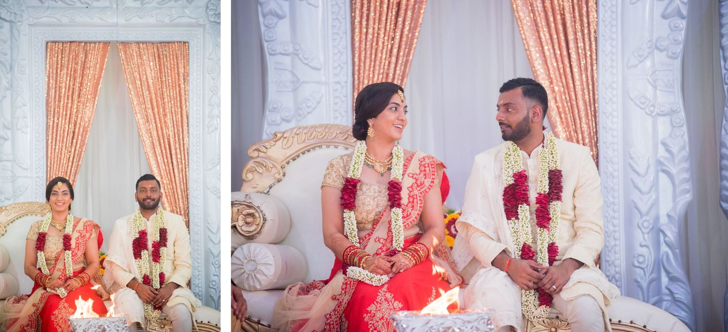 Couple seated on ornate chairs during traditional Indian wedding ceremony.