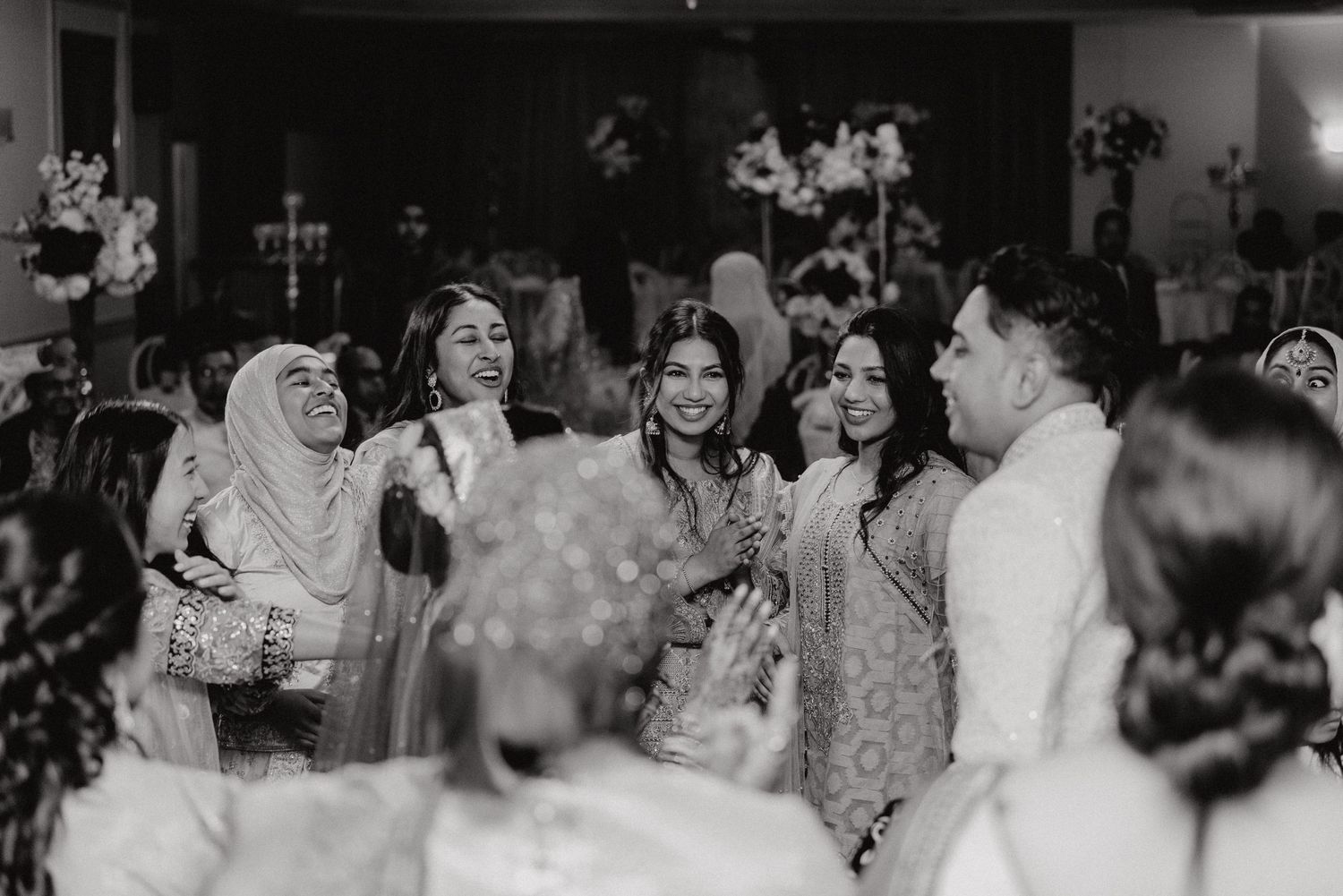 Black and white photo of wedding guests celebrating during the reception.