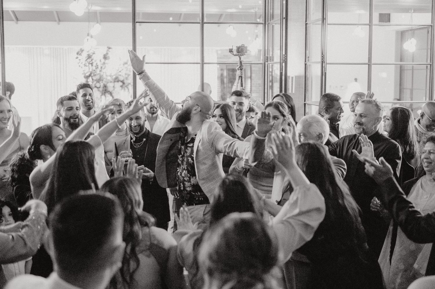 Vintage black and white photograph showing people dancing energetically at a celebration.