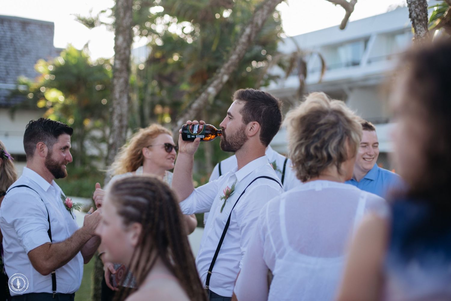 Wedding guests enjoying drinks and socializing at an outdoor celebration.