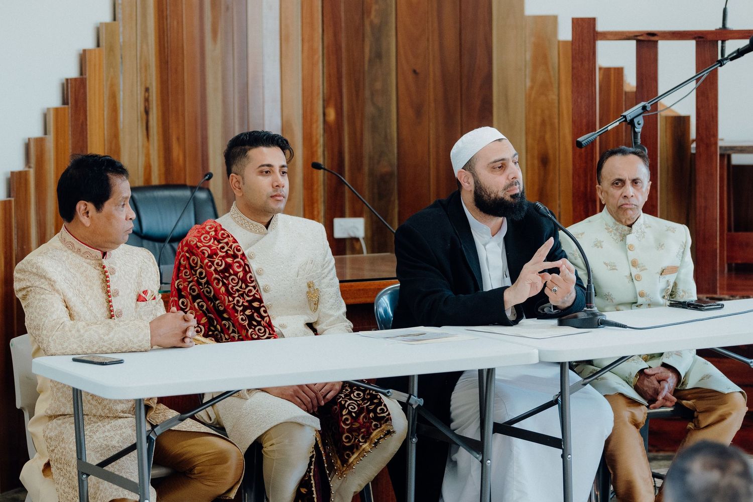 Four people seated at a conference table during what appears to be a formal meeting or discussion.