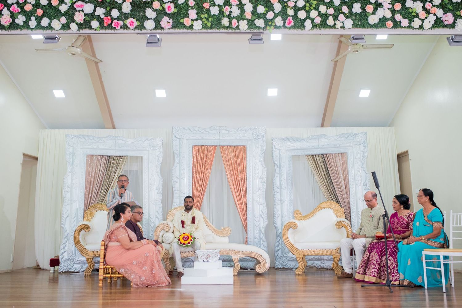 Elegantly decorated wedding venue with floral accents and ornate seating arrangements.