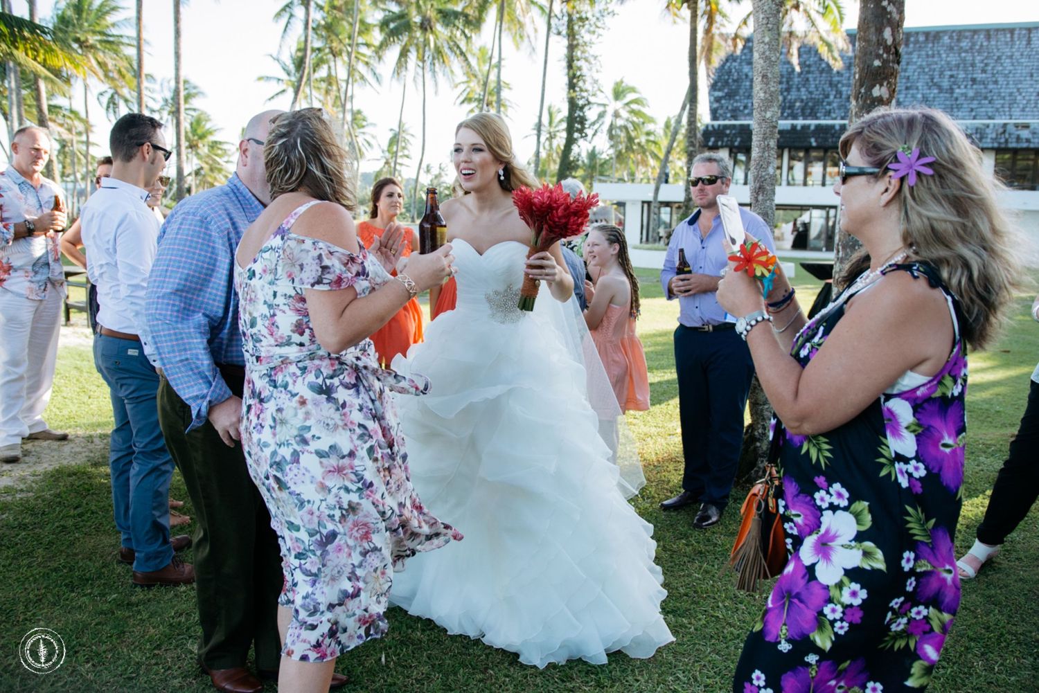 A wedding celebration on a tropical lawn with guests in summer attire.