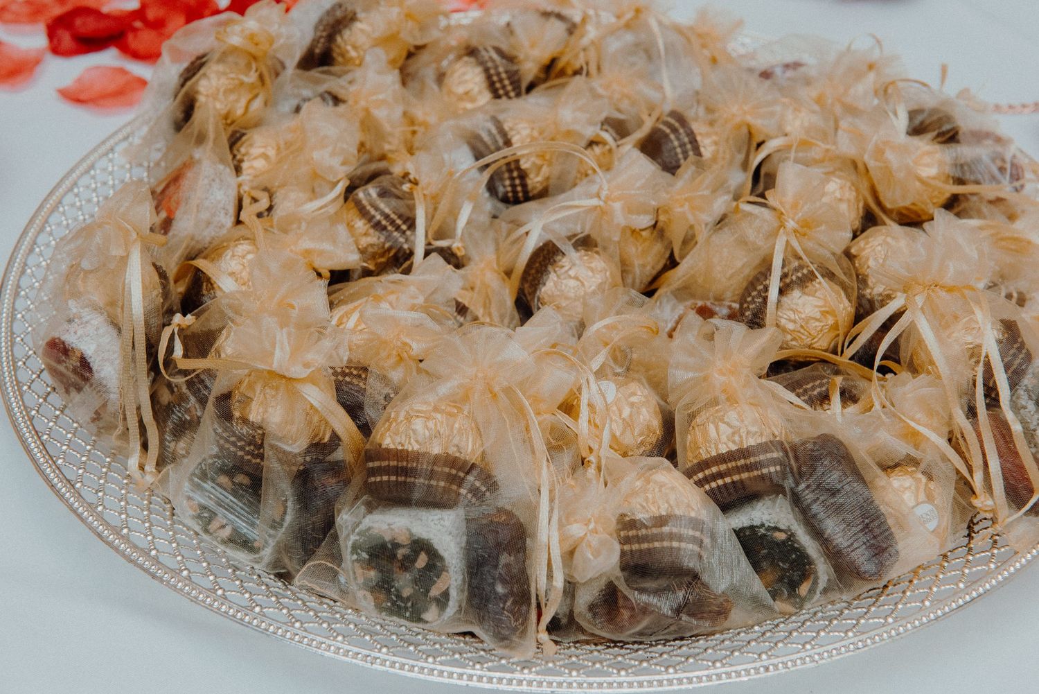 Platter of wrapped desserts or snacks arranged on a decorative glass plate at a wedding reception.