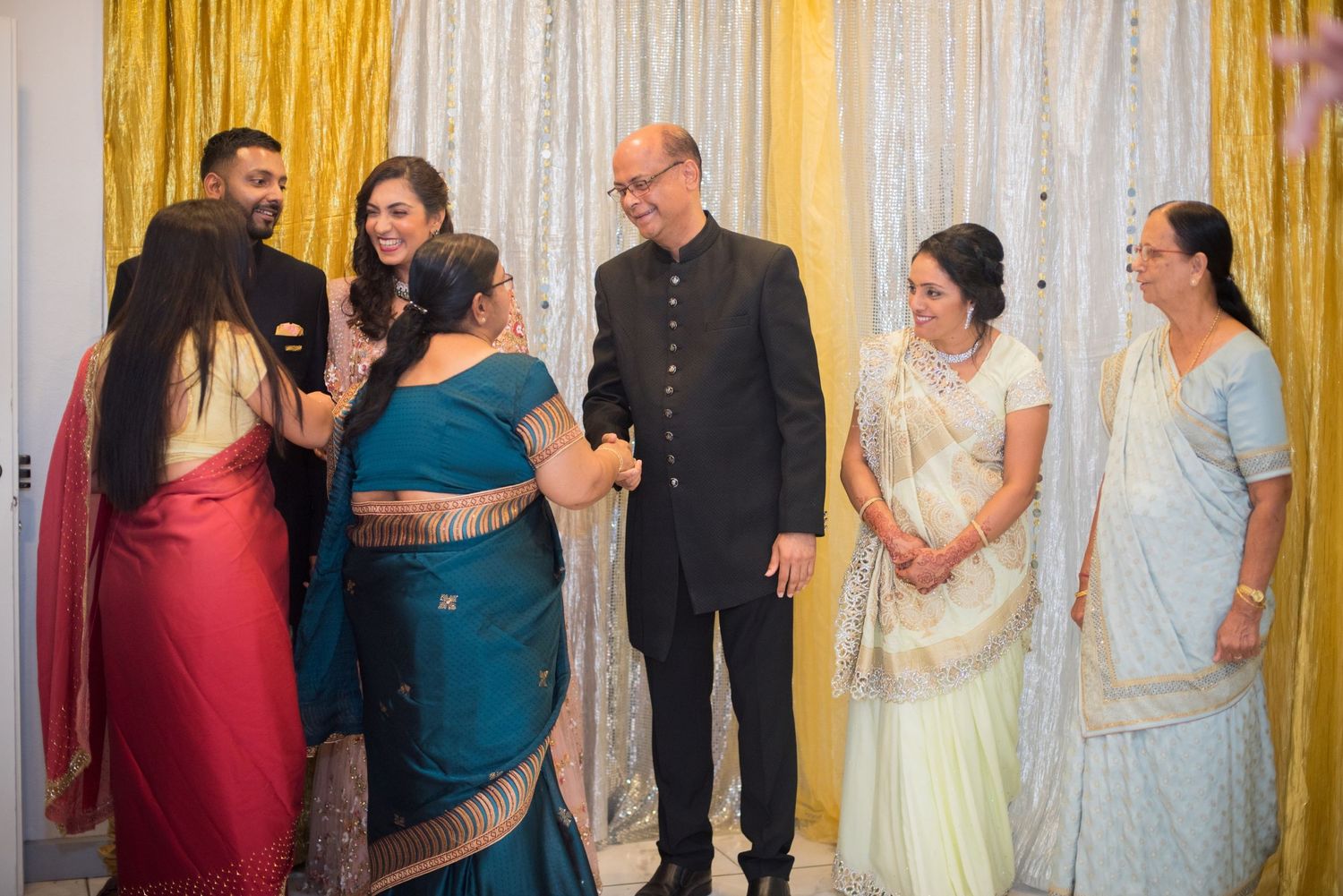 Group gathered at formal event with elegant backdrop and decorative lighting.
