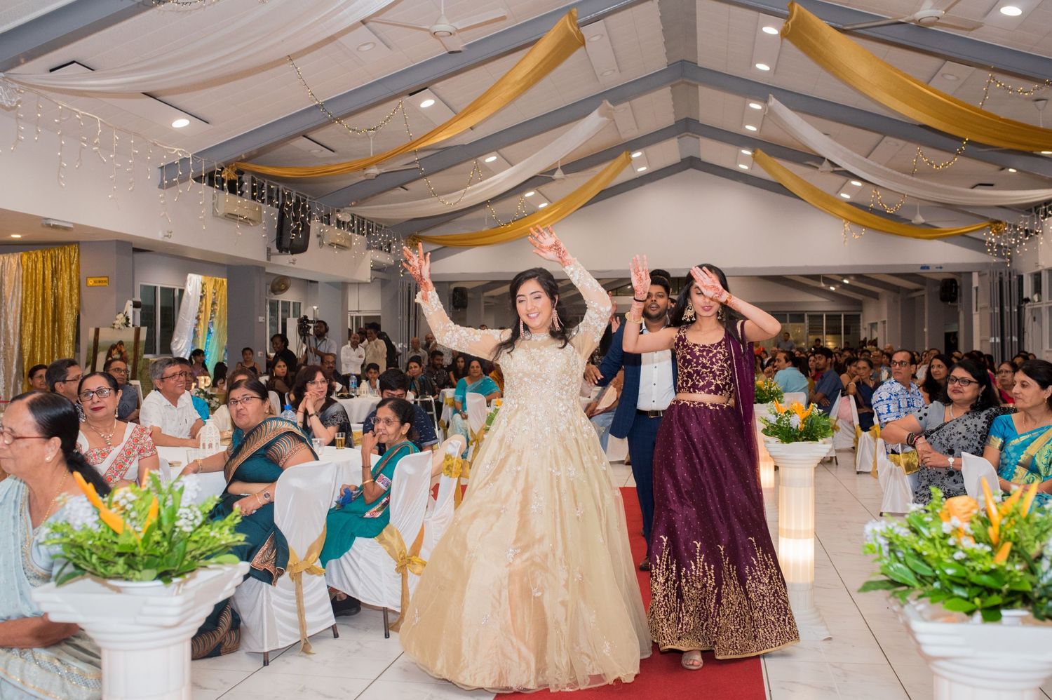 Two people in formal attire dancing on red carpet during celebration event.