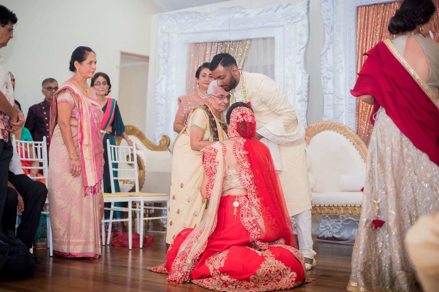 Wedding ceremony ritual taking place with guests observing in a decorated indoor venue.