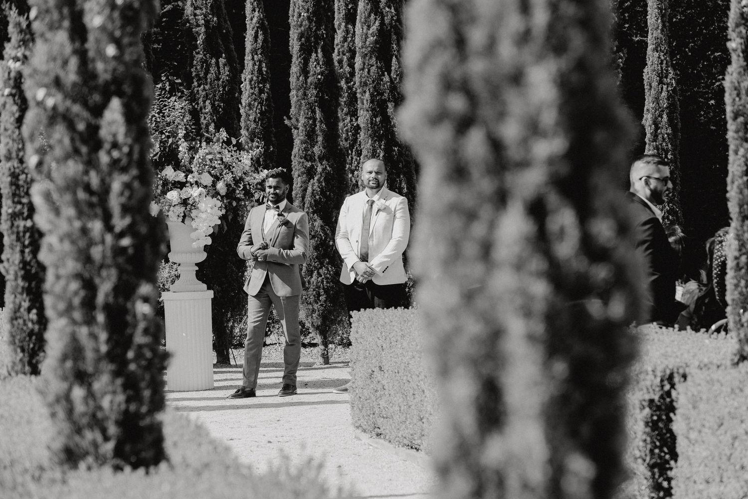 A couple walking together through a wooded trail captured in black and white photography.