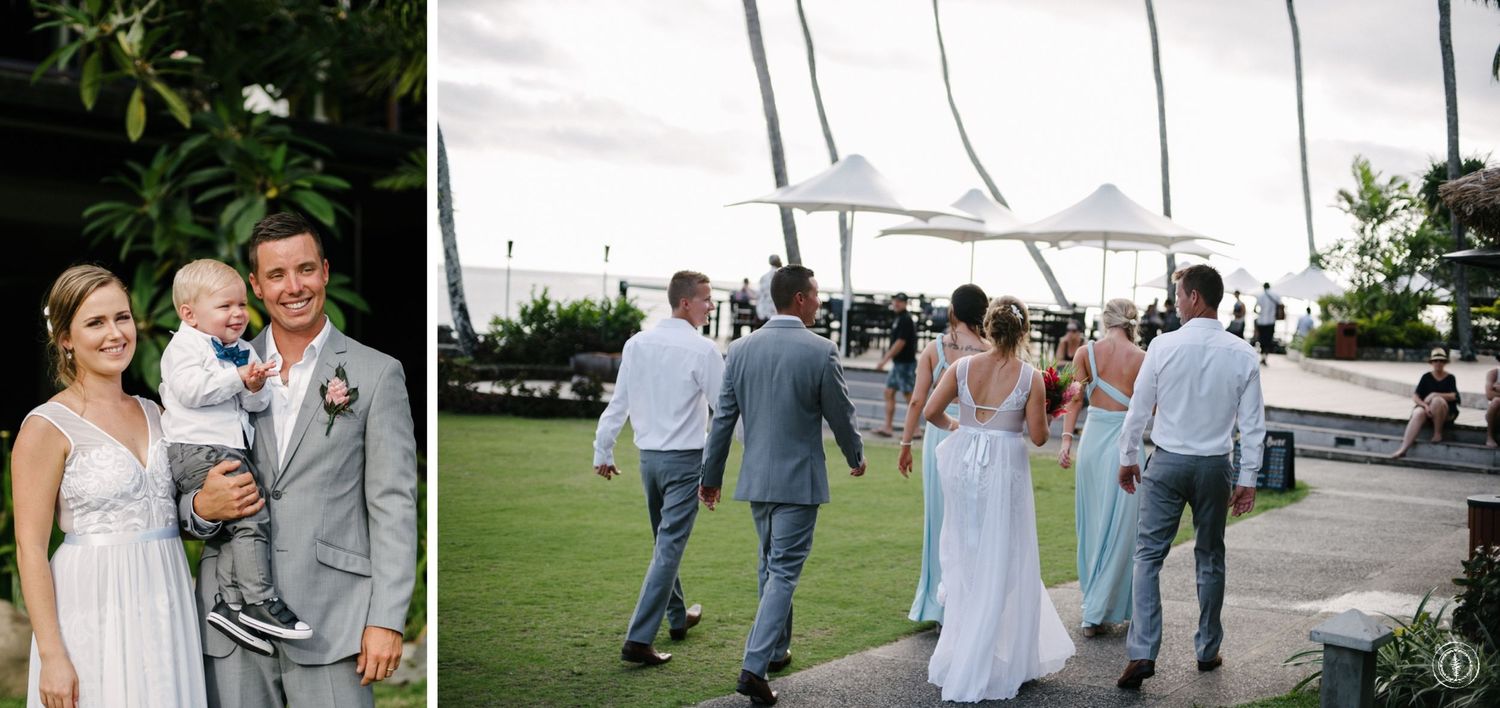 Wedding party walking on lush tropical grounds with palm trees and ocean views.