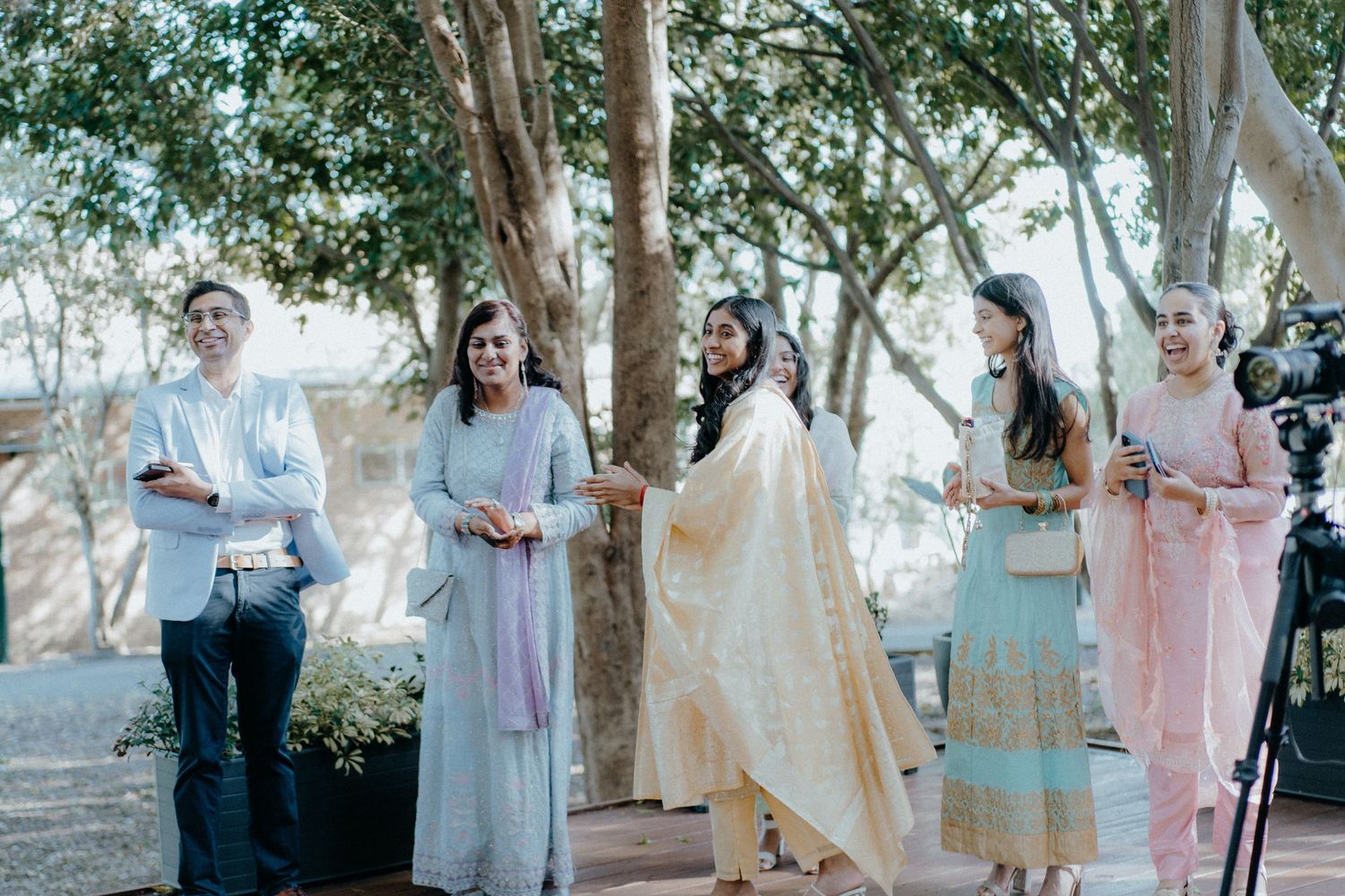 Wedding guests in traditional attire gather outdoors during ceremony celebrations.