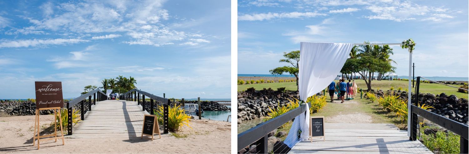 Beachfront wedding ceremony setup with white chairs and decorations under blue skies.