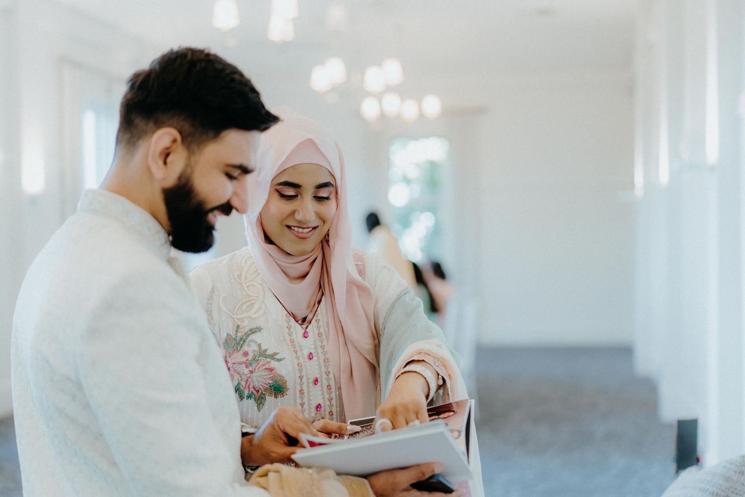 A couple sharing a tender moment while looking at documents together in a bright indoor setting.