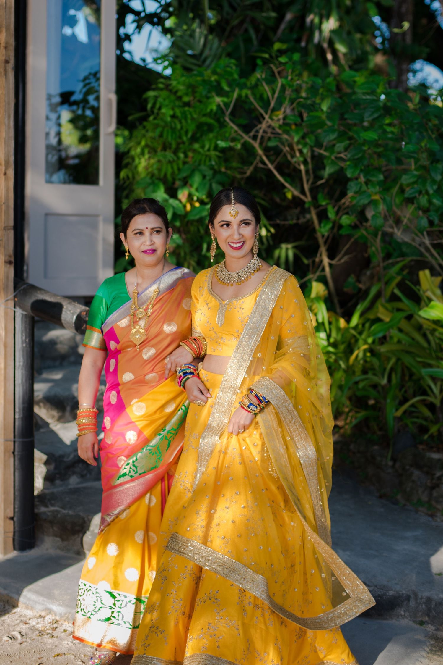 Vibrant traditional Indian wedding attire in yellow and pink with detailed embroidery.
