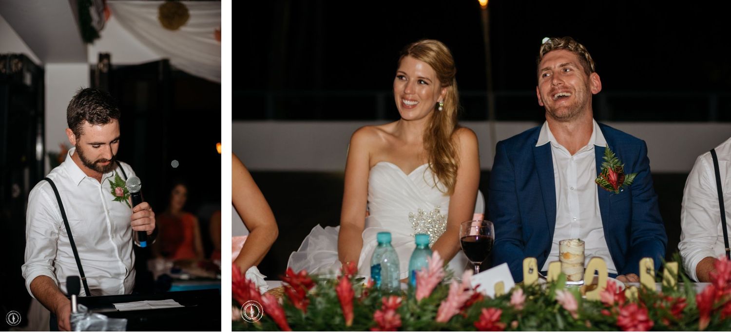 A couple shares a moment at their wedding reception dinner table surrounded by elegant decor.