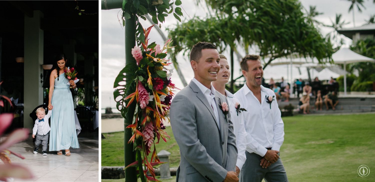 Outdoor wedding ceremony setup with tropical floral arrangements and palm trees in the background.