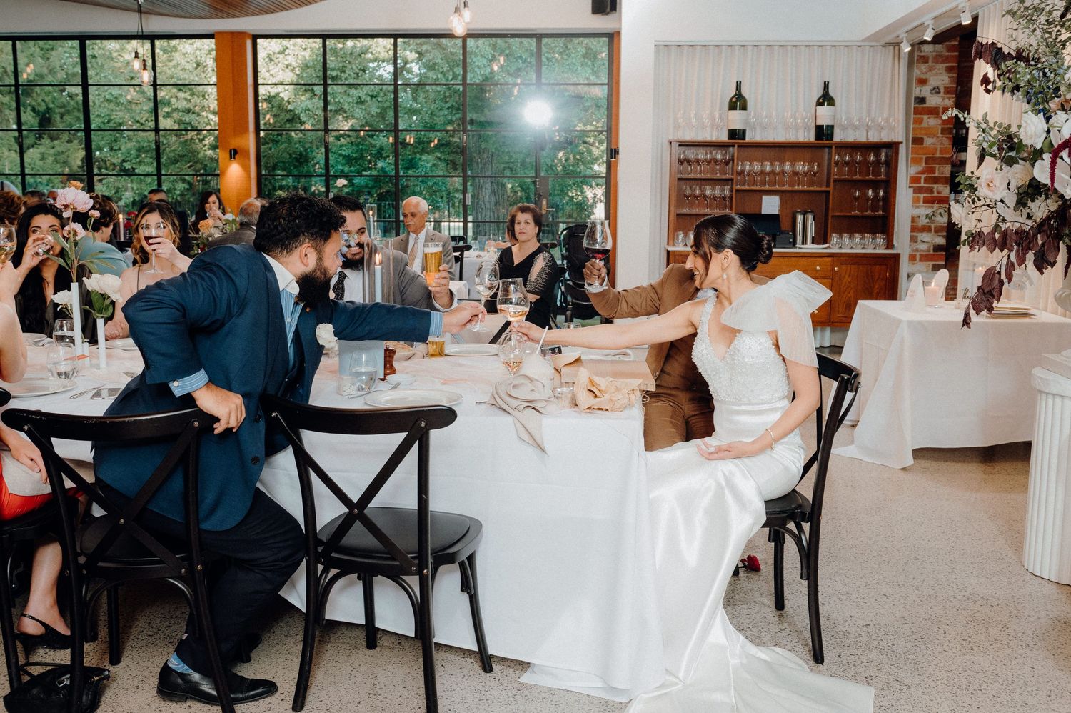 Candid moment of laughter between guests at wedding reception table.