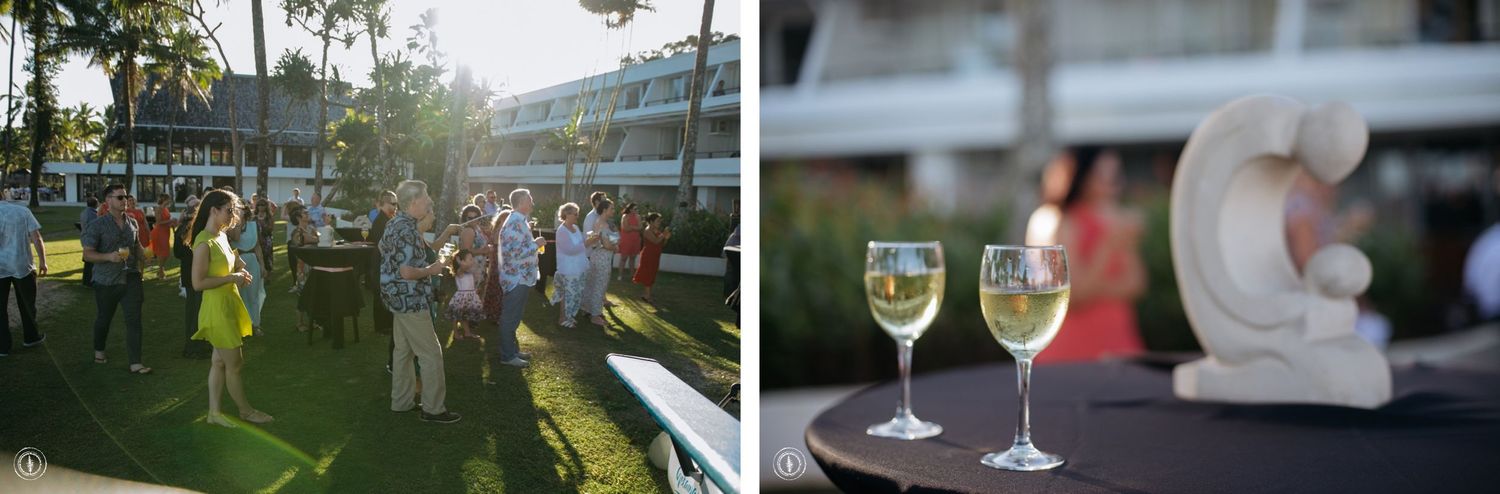 Wedding reception on a lawn with palm trees and wine glasses in the foreground.