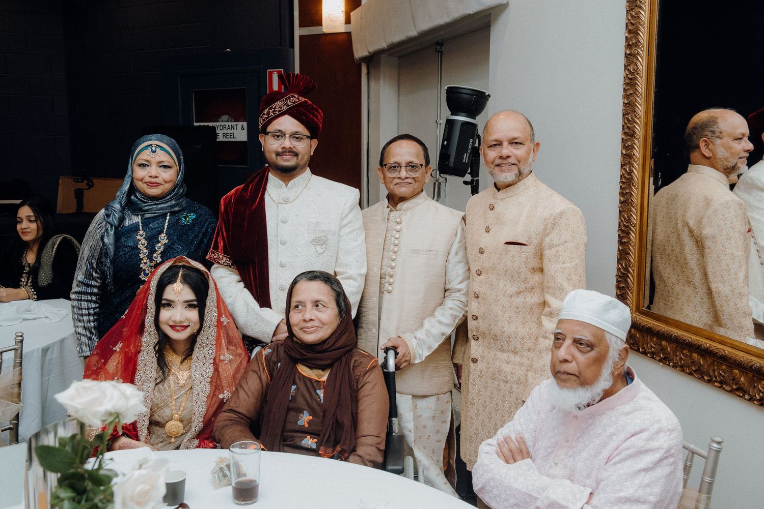 Family gathering at traditional South Asian wedding celebration.
