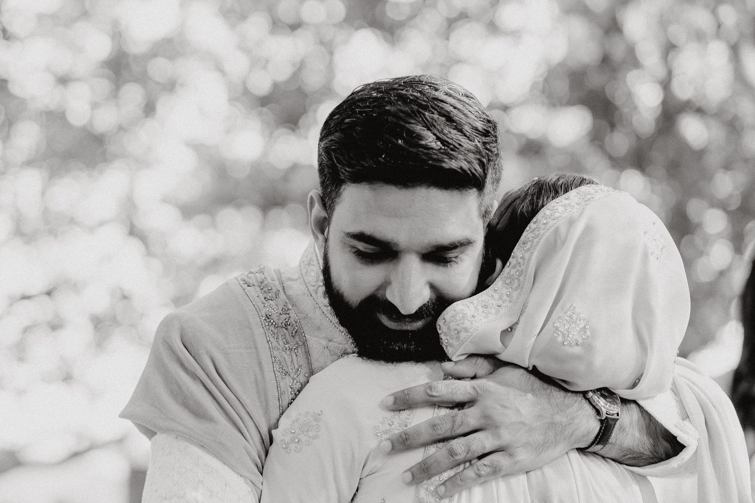 An intimate black and white portrait of a couple sharing a tender moment.