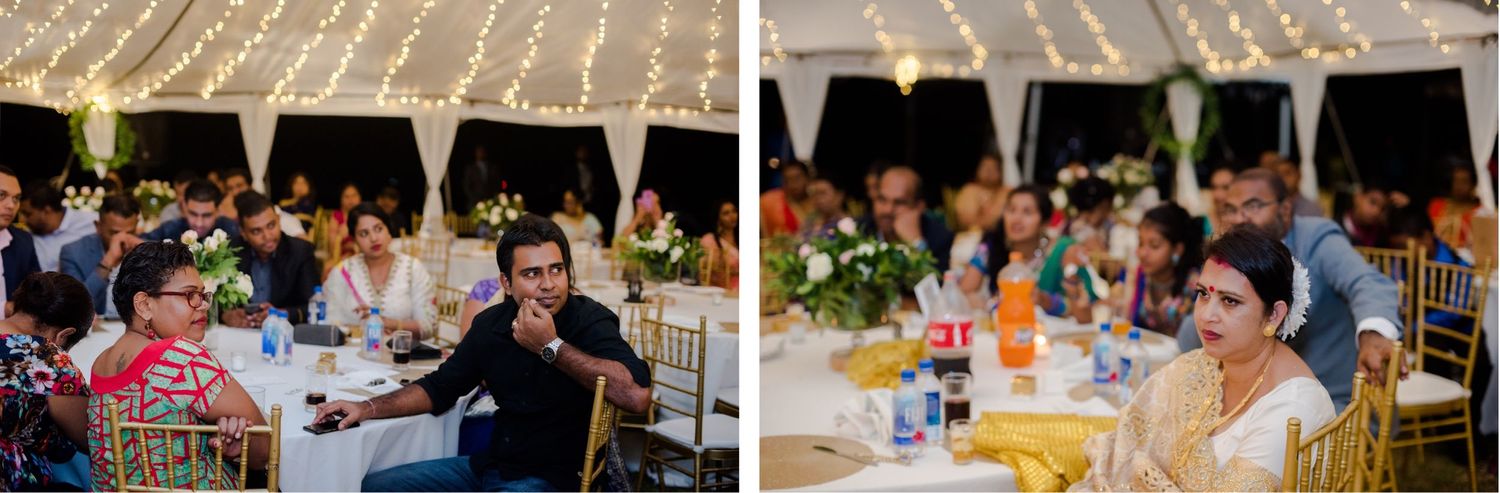 Wedding guests seated at outdoor reception tables enjoy dinner under string lights.