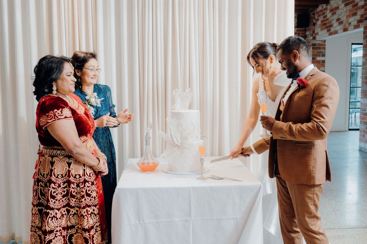 Wedding party members gathered around a white-clothed table during reception ceremony.