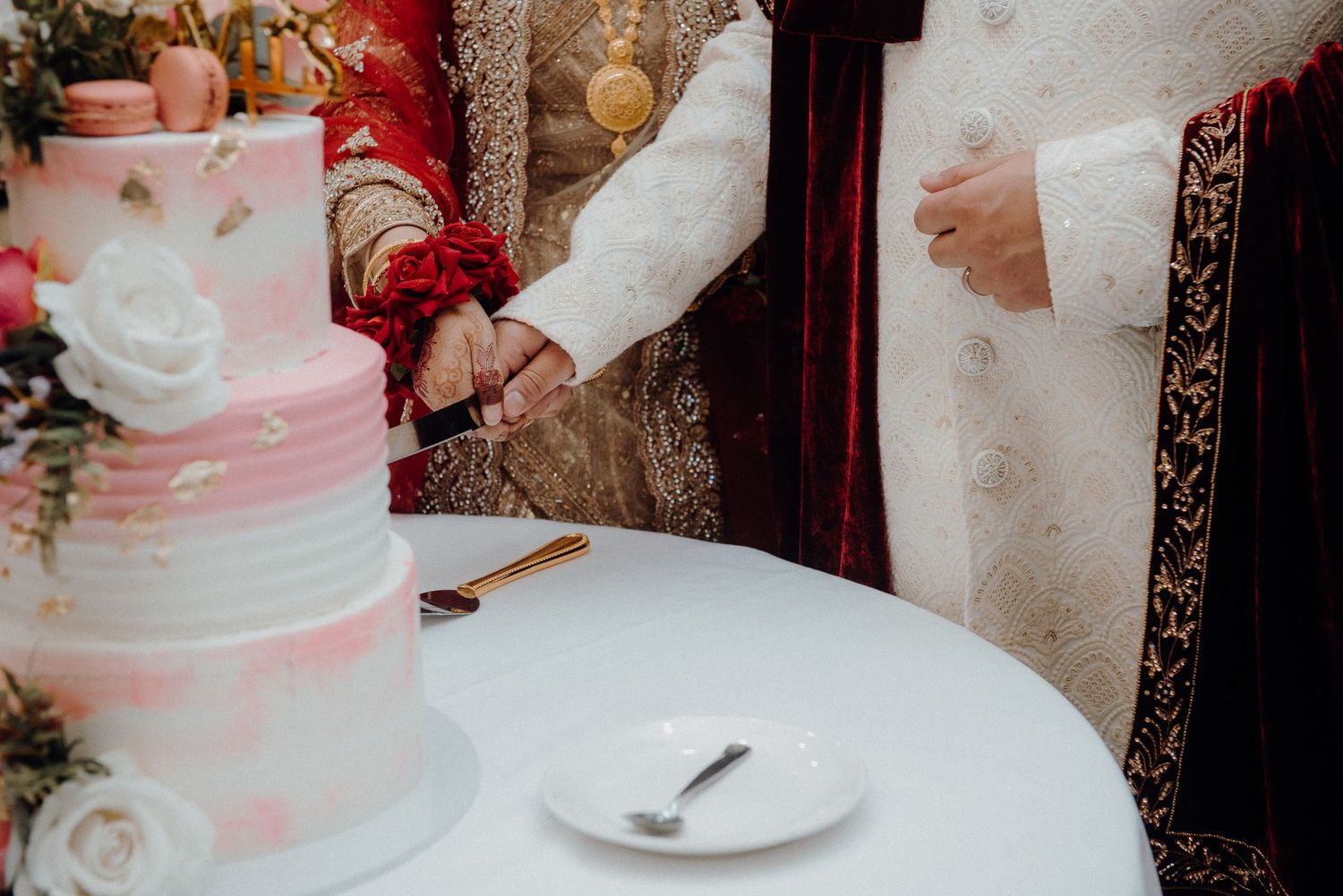 Close-up of a beautifully decorated wedding cake with pink roses and white frosting.
