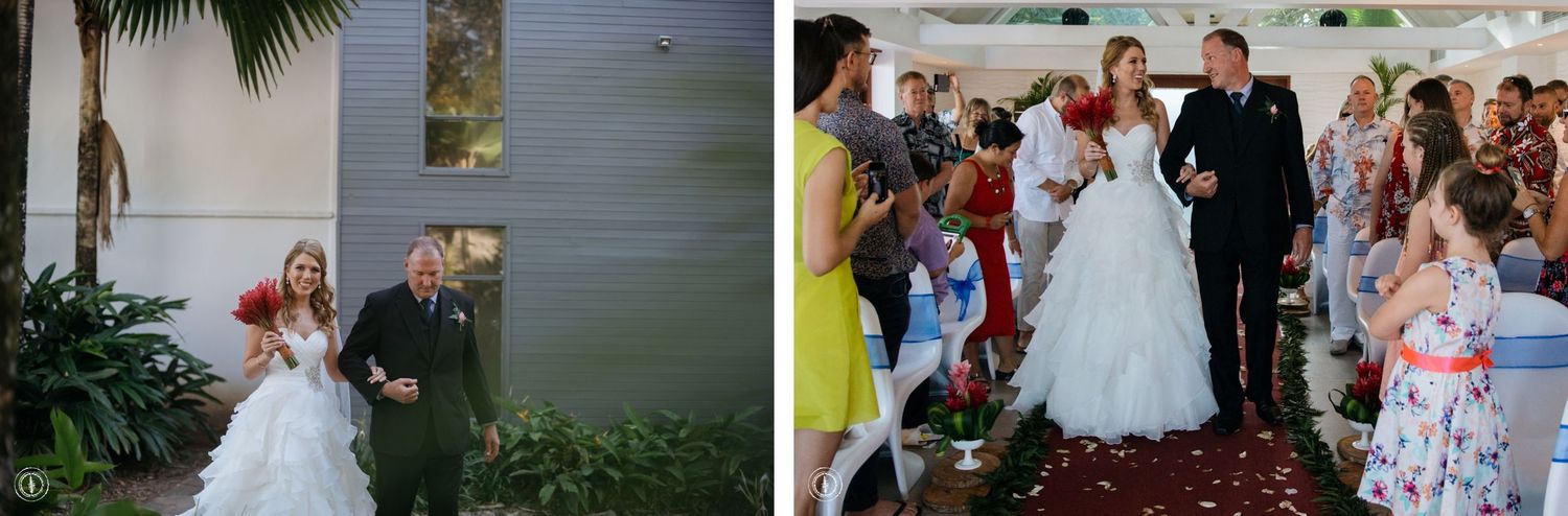 Wedding ceremony processional with guests lining the red carpet aisle.