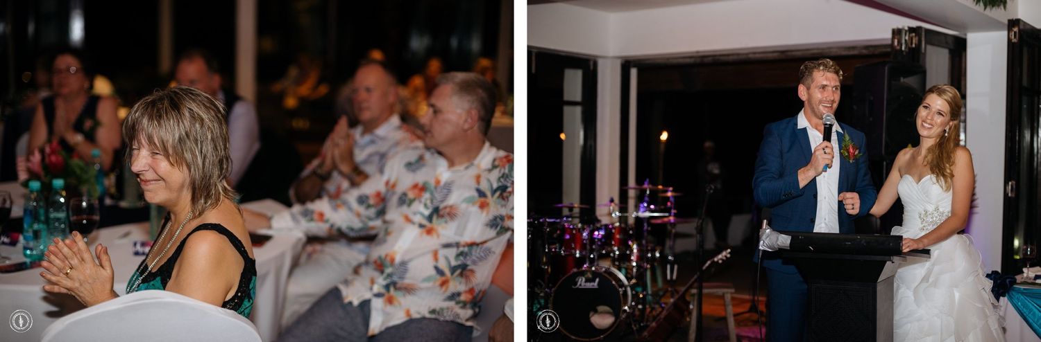 Wedding reception guests enjoy speeches while celebrating at decorated tables.