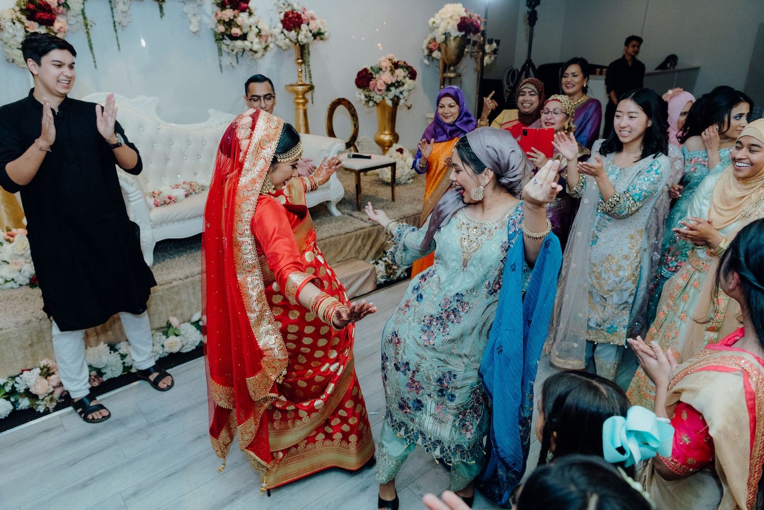 Wedding celebration featuring traditional dance performances in a decorated indoor setting.