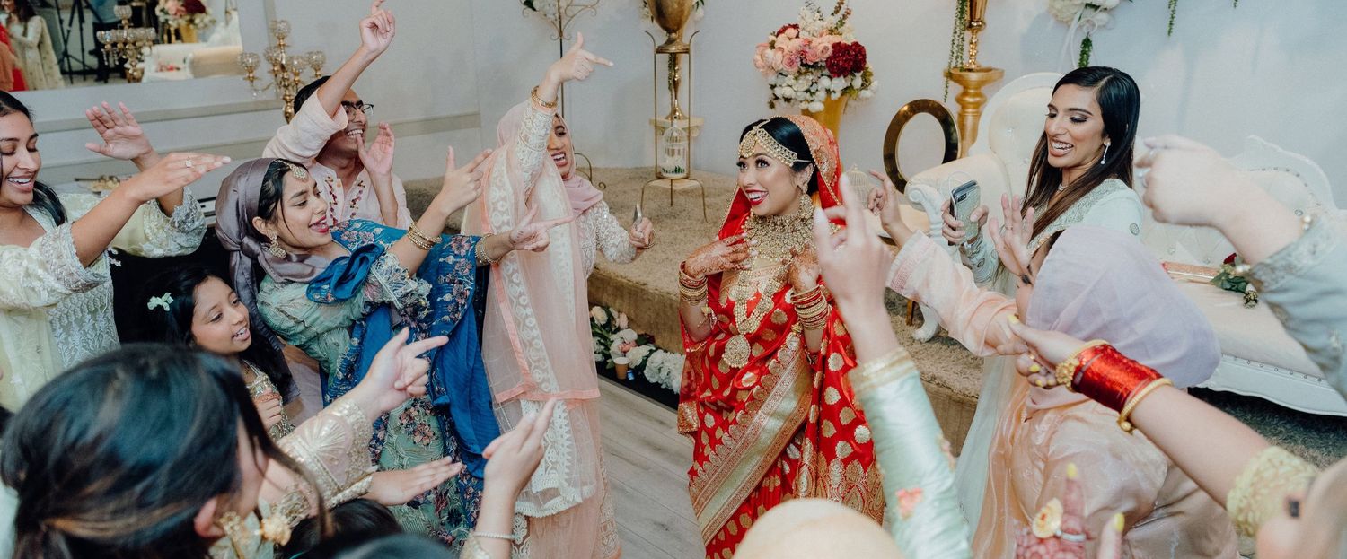 Festive dance celebration at wedding with guests in colorful traditional clothing.
