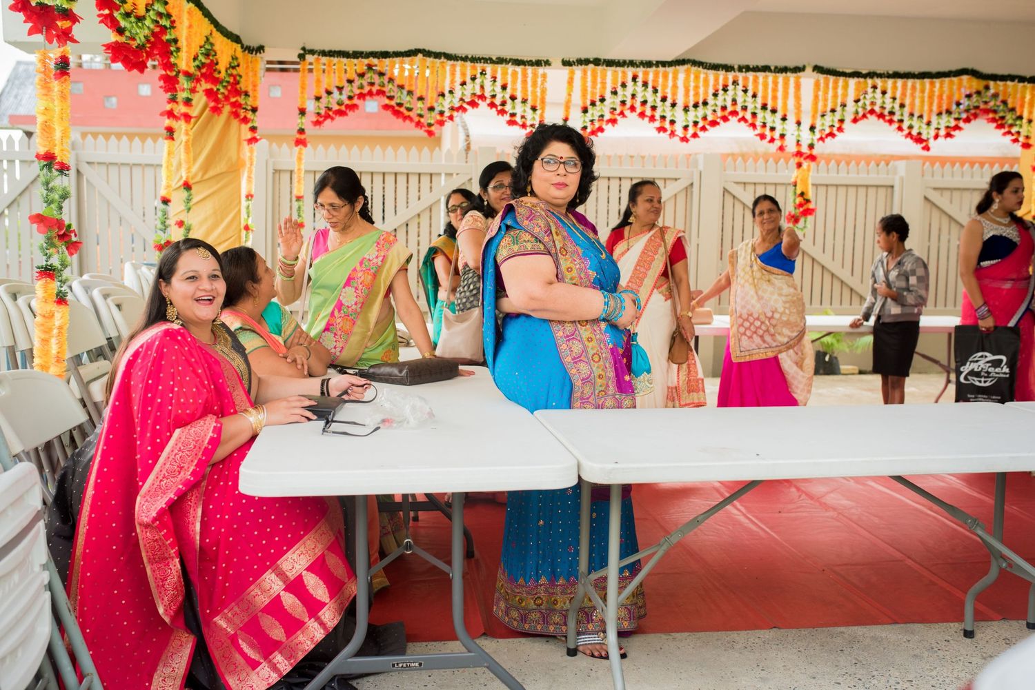Celebrants gather at decorated tables during a festive Indian cultural event with bright decorations.