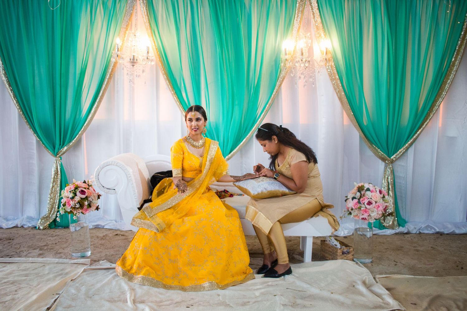 Elegant turquoise and white draped backdrop with chandelier lighting sets the scene for a formal celebration.