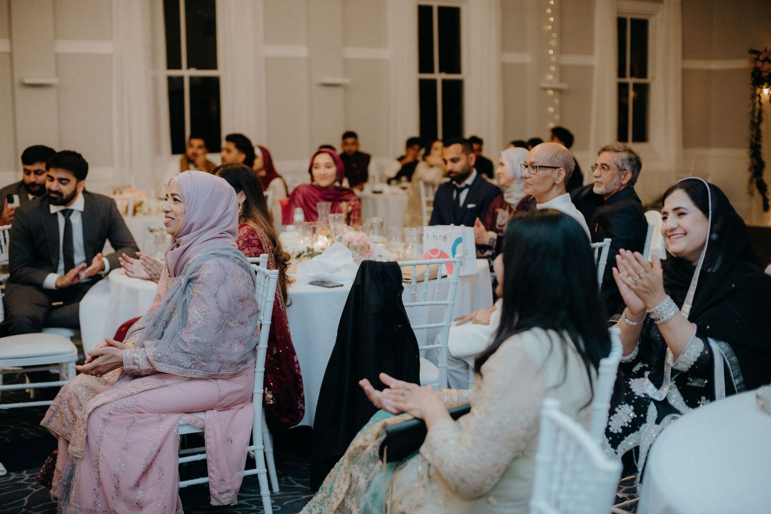 Wedding reception guests enjoying celebrations at elegant indoor venue.