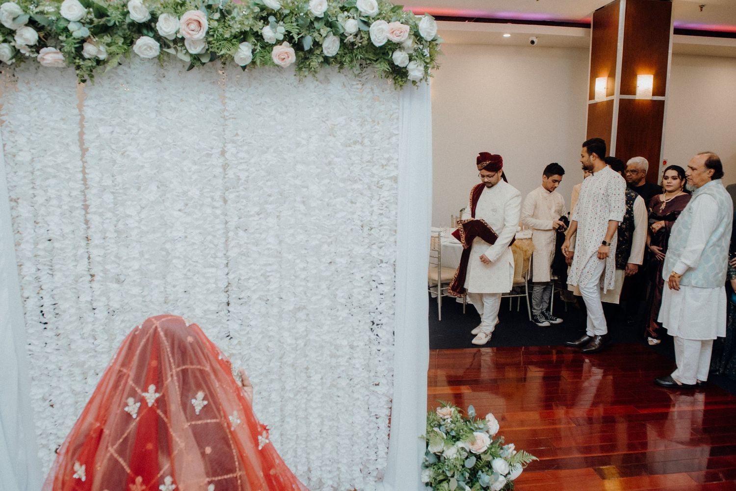 A wedding ceremony setup with floral arch and traditional South Asian decor elements.