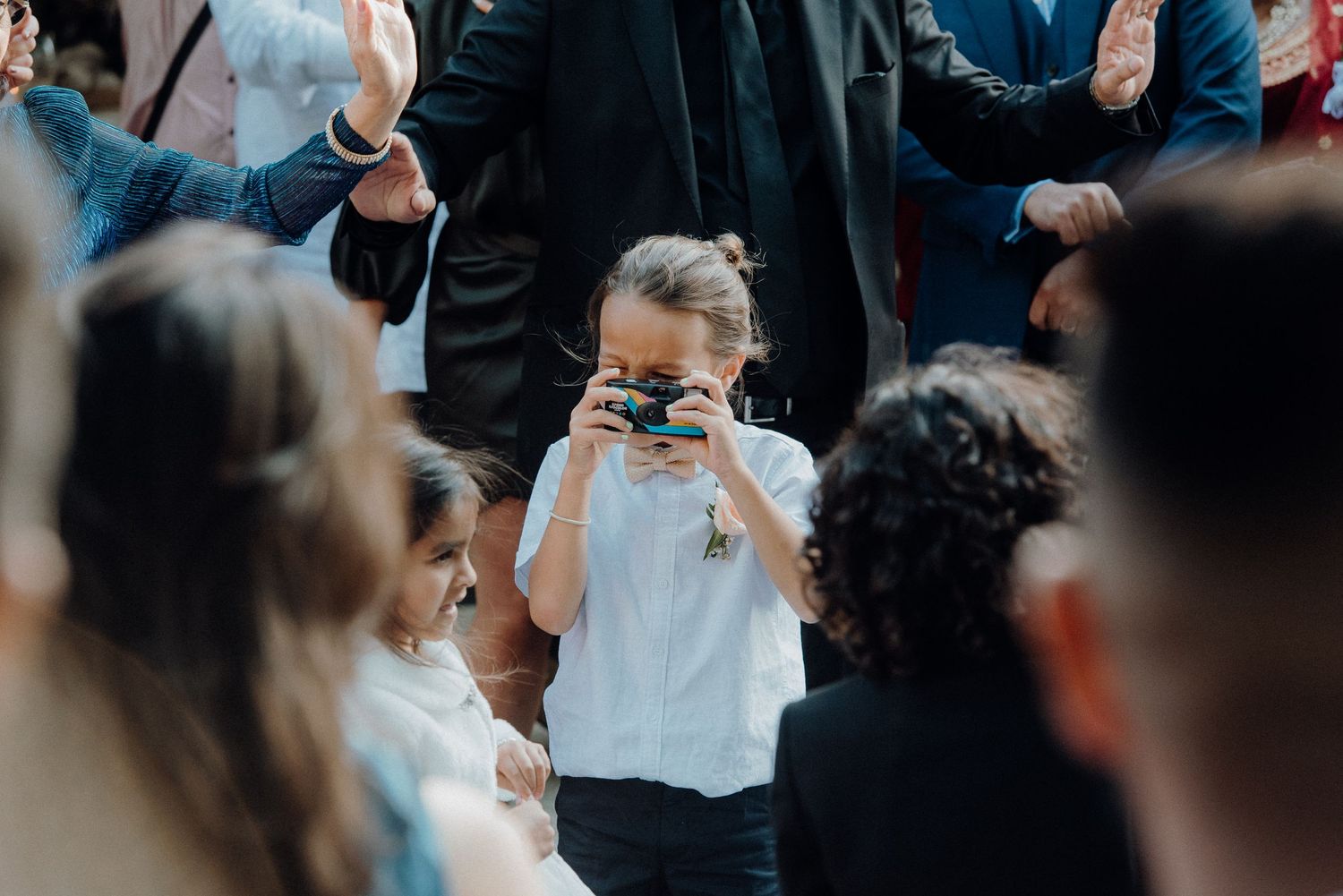 Young guest takes photos with a camera during a wedding celebration.