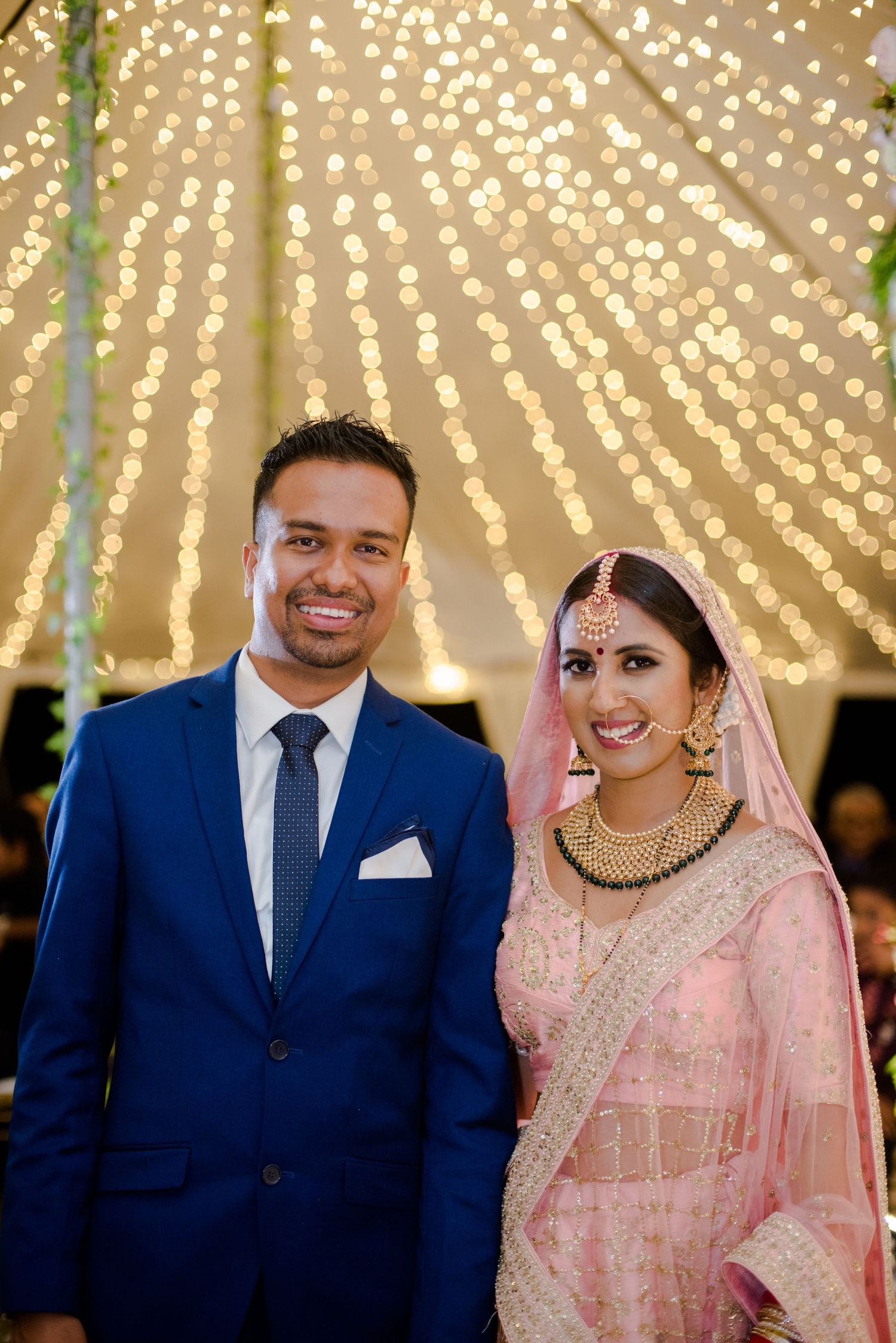 A wedding celebration under a canopy of twinkling string lights creating a magical atmosphere.
