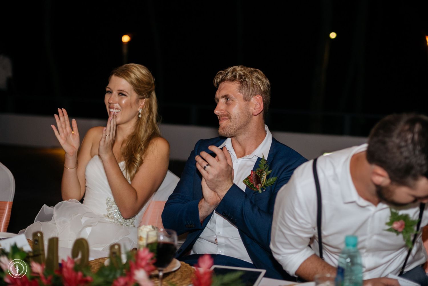 A couple reacts emotionally during wedding reception toasts at an elegant evening celebration.