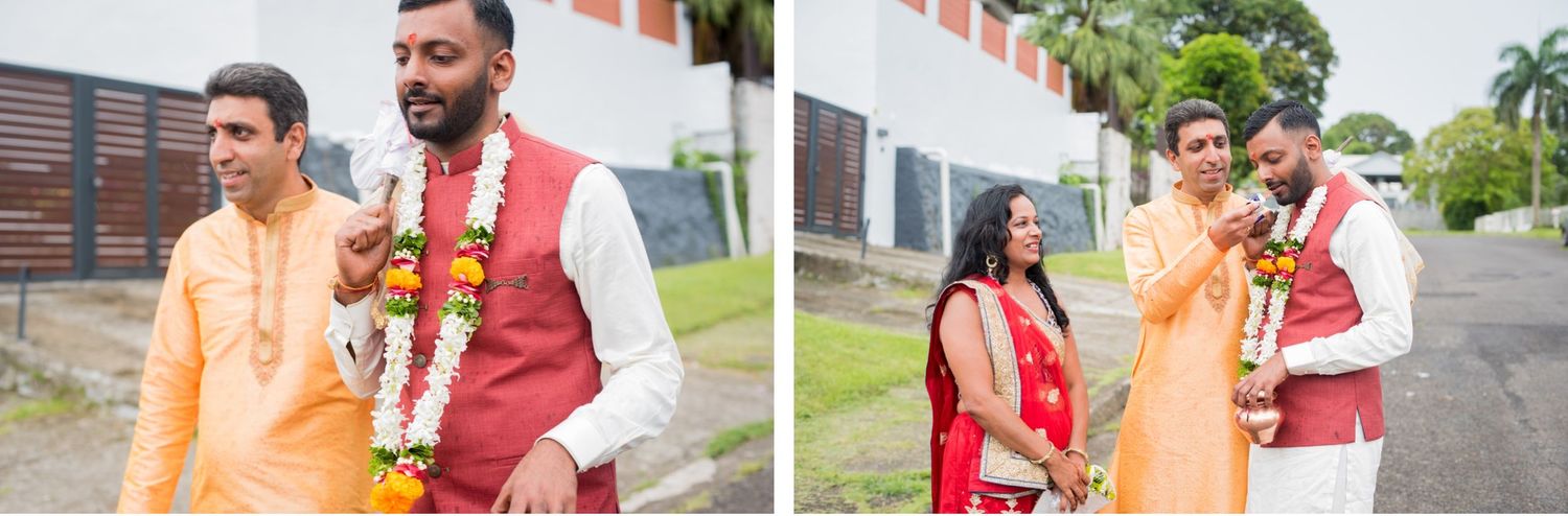 Two people in traditional Indian wedding attire standing together outdoors wearing colorful garments.