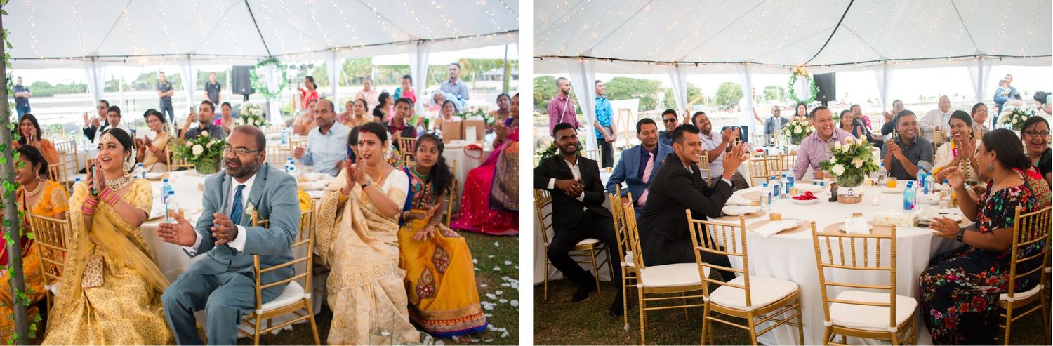 Wedding reception under a tent with guests seated at decorated tables.