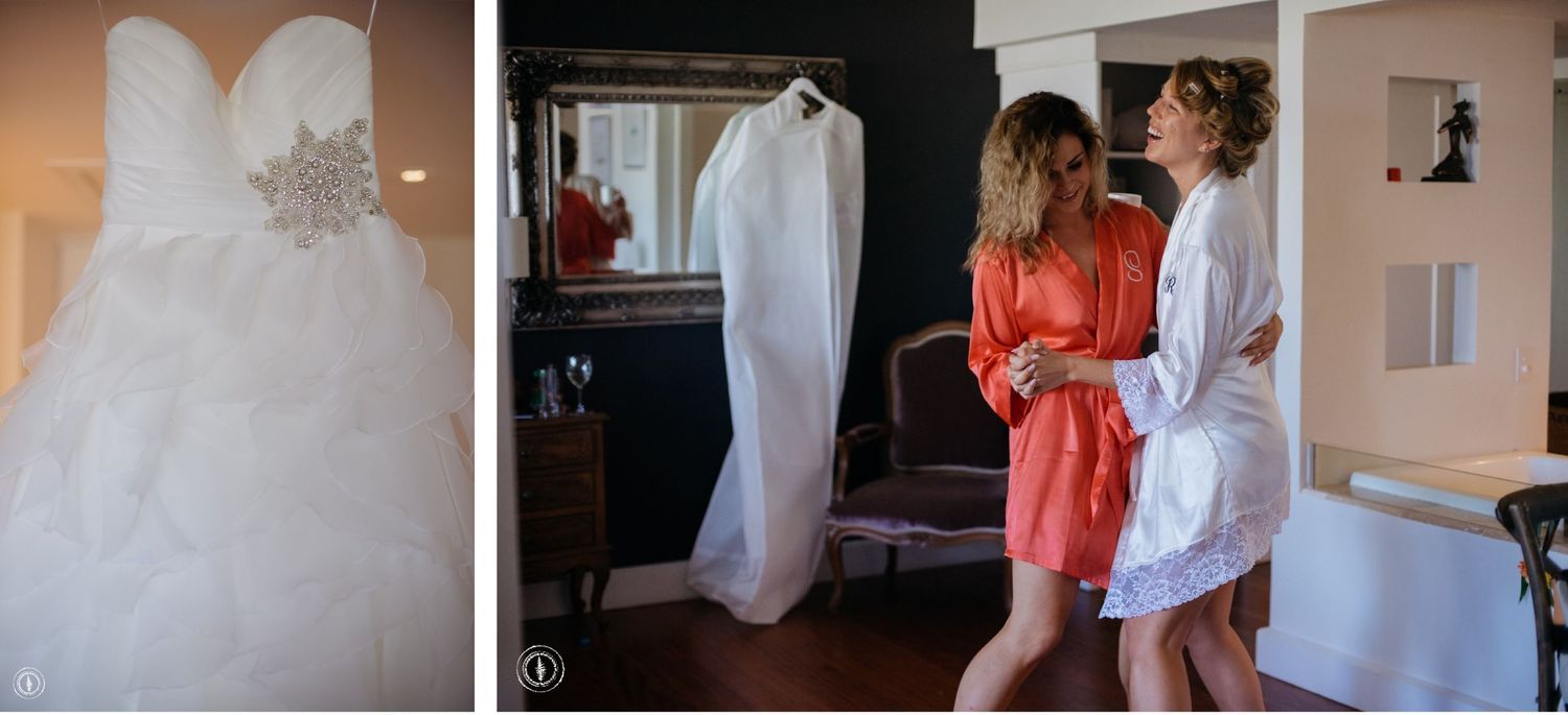 A white wedding dress hanging next to people getting ready in robes for a special event.