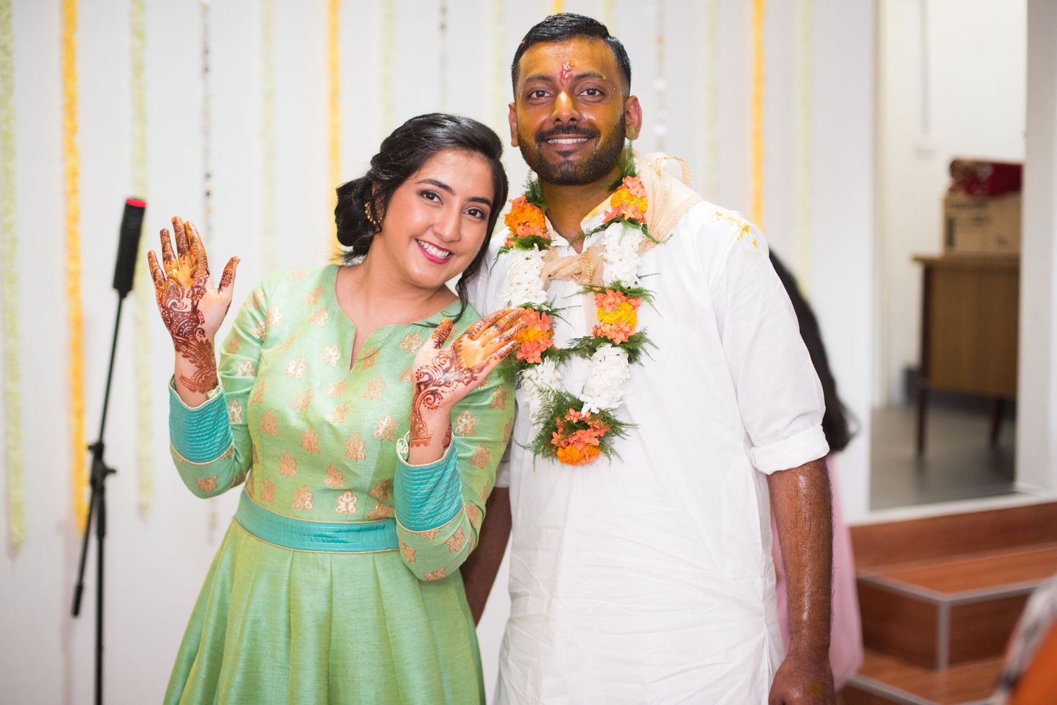 Couple in traditional Indian attire posing together at a celebration.