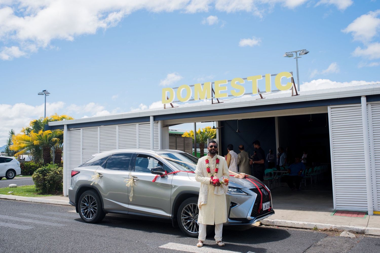 A silver SUV parked outside a business building with person in traditional clothing.