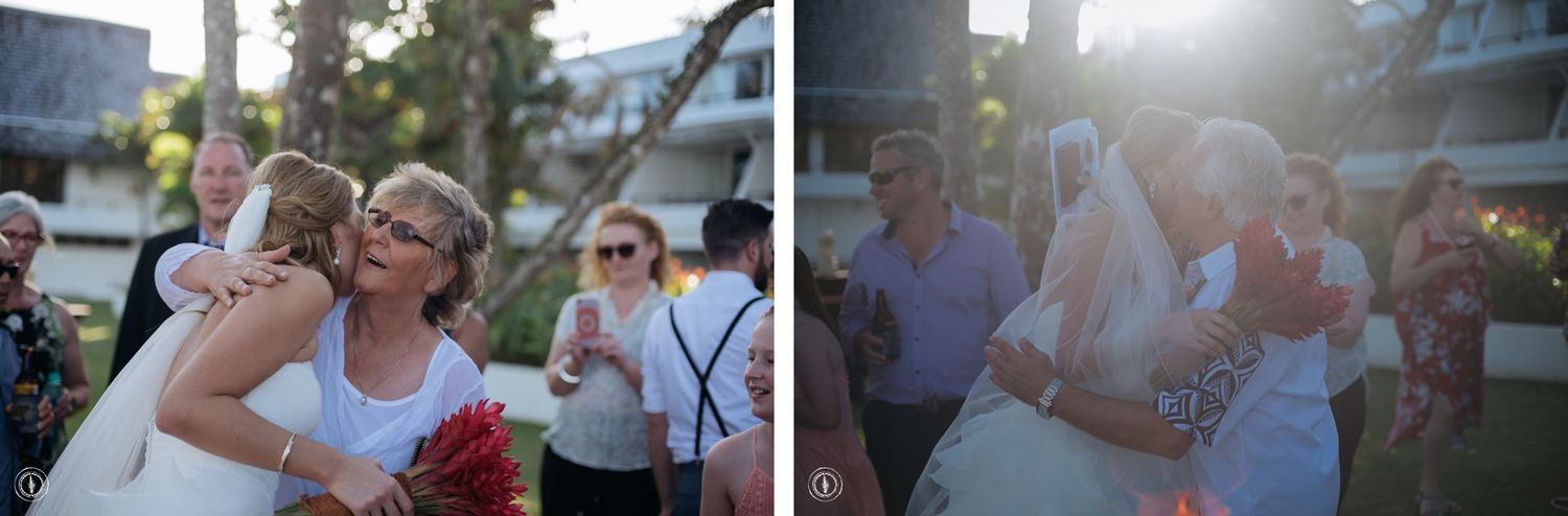 Two people embrace during a celebratory outdoor wedding reception at sunset.