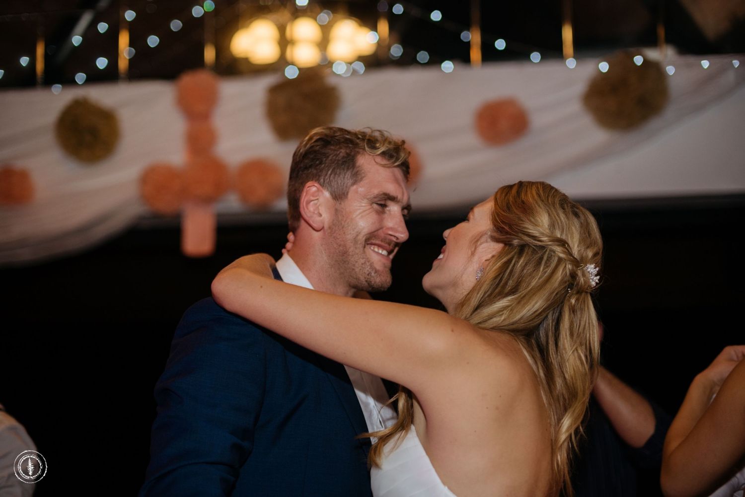 A joyful moment shared between a couple during their wedding dance under twinkling lights.