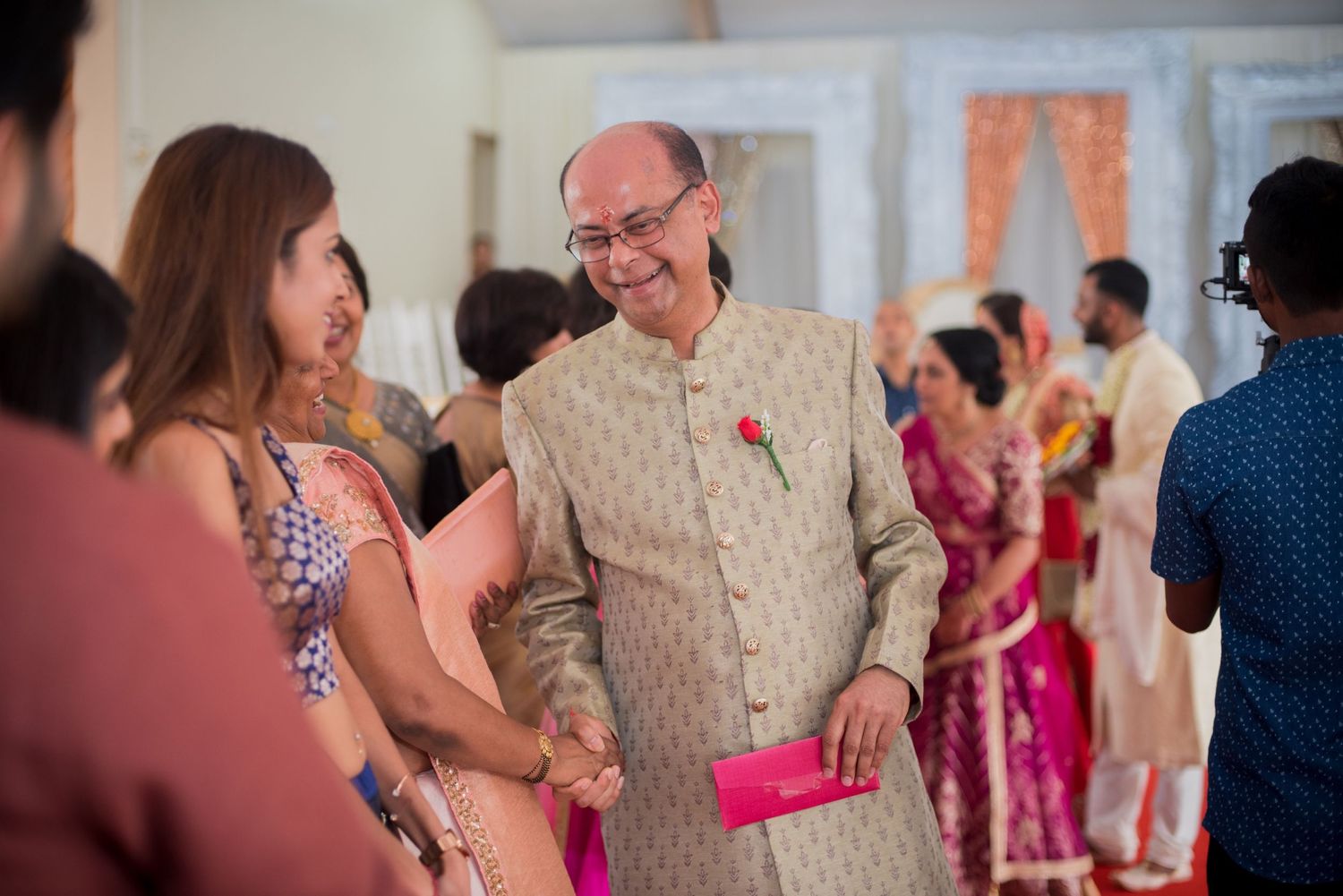 Guests interact during a festive indoor celebration featuring traditional attire and decorations.