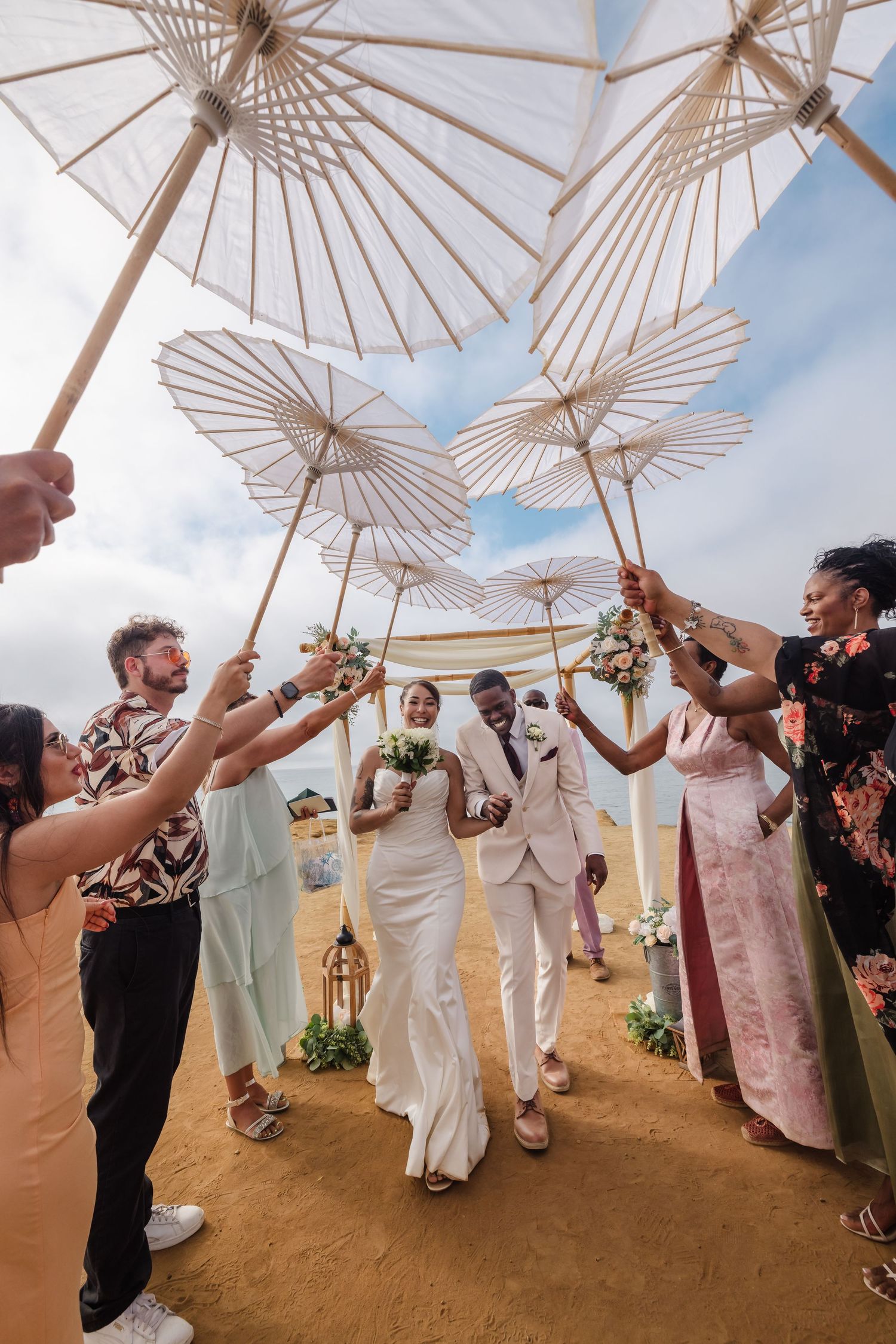 San Diego Sunset Cliffs wedding photography by Jenny Thai Photography -  biracial mixed couple walking under umbrellas