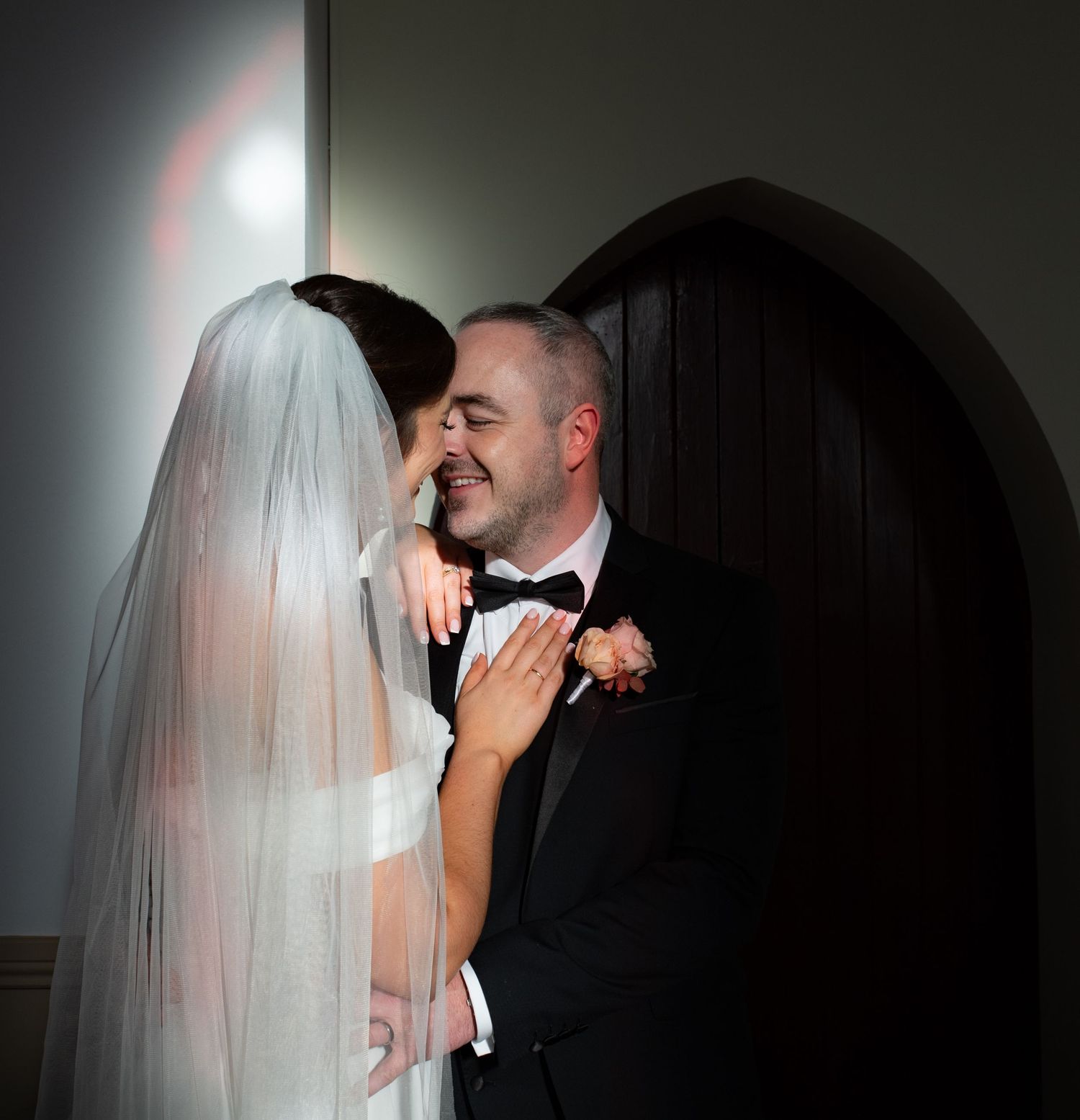 Dramatic black and white wedding portraits with artistic lighting and shadows.