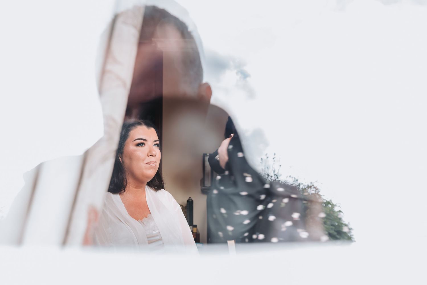 Dreamy double exposure portrait of smiling bride in white wedding dress.