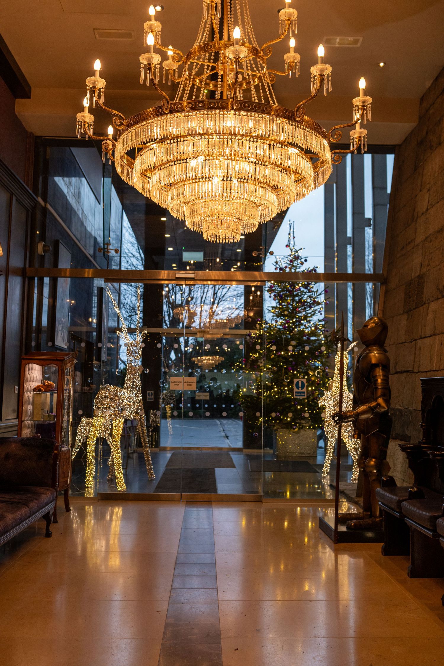 Elegant hallway with crystal chandeliers and natural lighting.